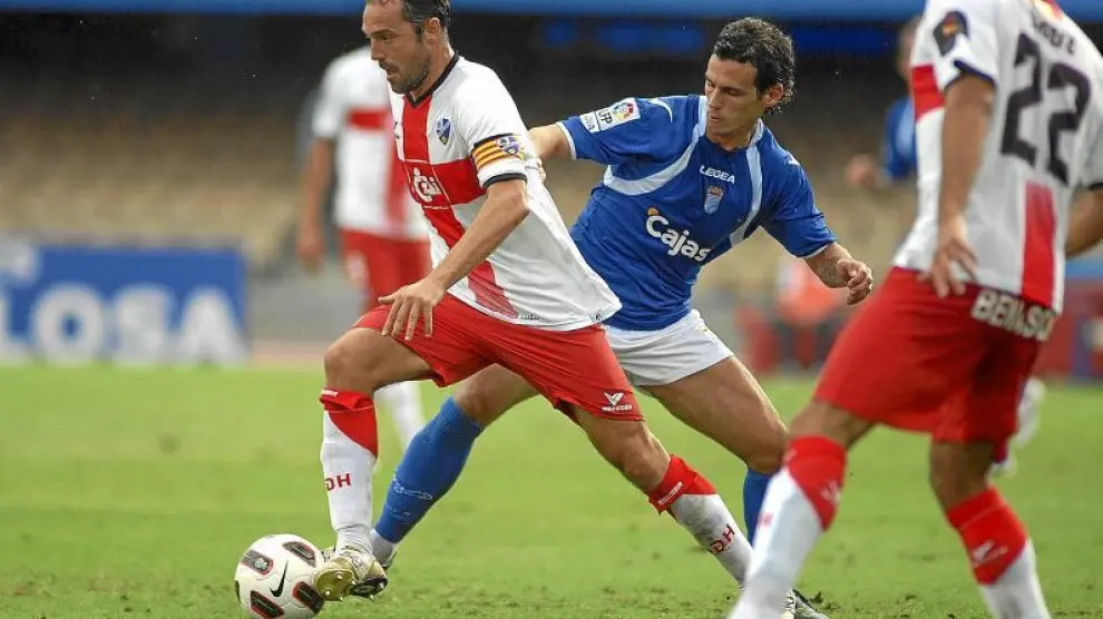 Luis Helguera conduce el balón y salva la entrada de un futbolista del Xerez durante el partido de ayer en Chapín.