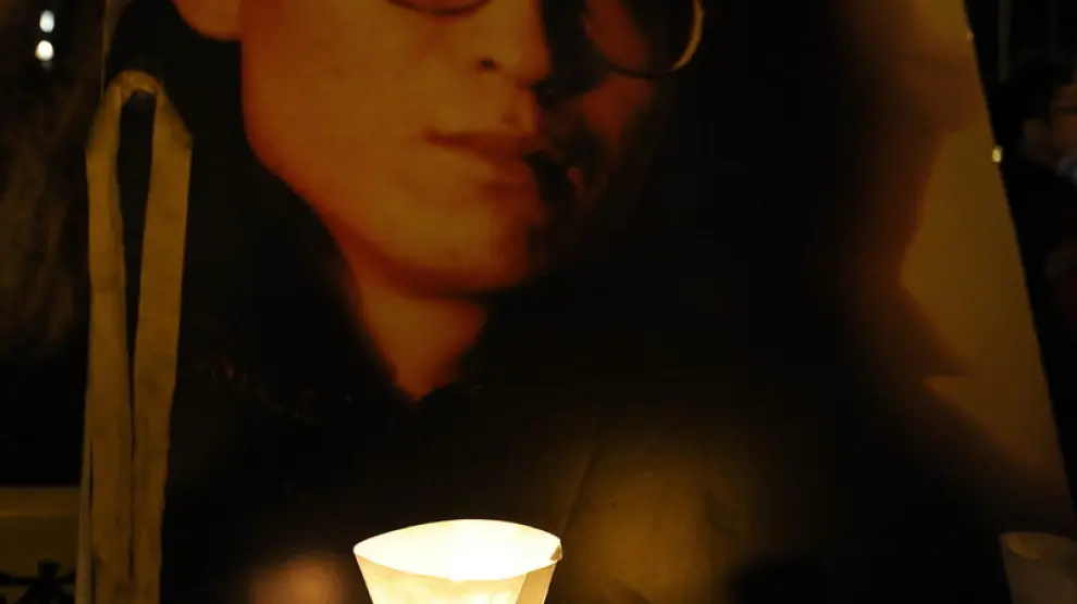 Una vela colocada junto a una imagen del nobel de la Paz 2010 Liu Xiaobo