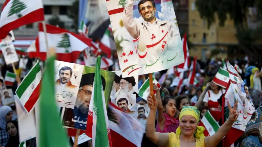 Un grupo de manifestantes libanesas reciben a Mahmud Ahmadineyad con banderas nacionales e iraníes