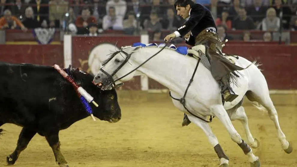 Momento culminante de la faena de Diego Ventura montando al caballo Morante, el tordo en fase blanca, que muerde a los toros.
