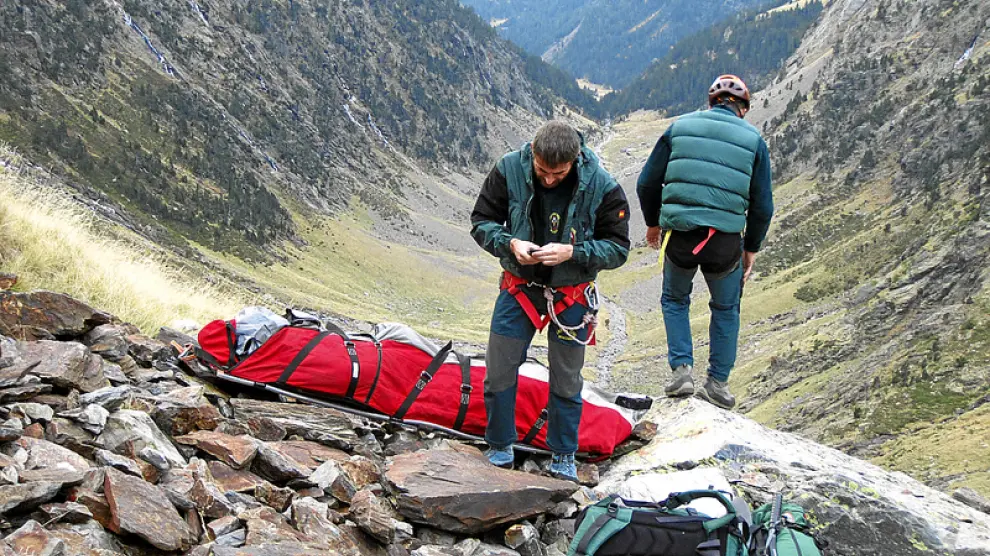 Dos guardiaciviles de Boltaña esperan, junto al cadáver, a que llegue el helicóptero para evacuar el cuerpo del francés que se despeñó en el pico Bachimala (Gistaín).