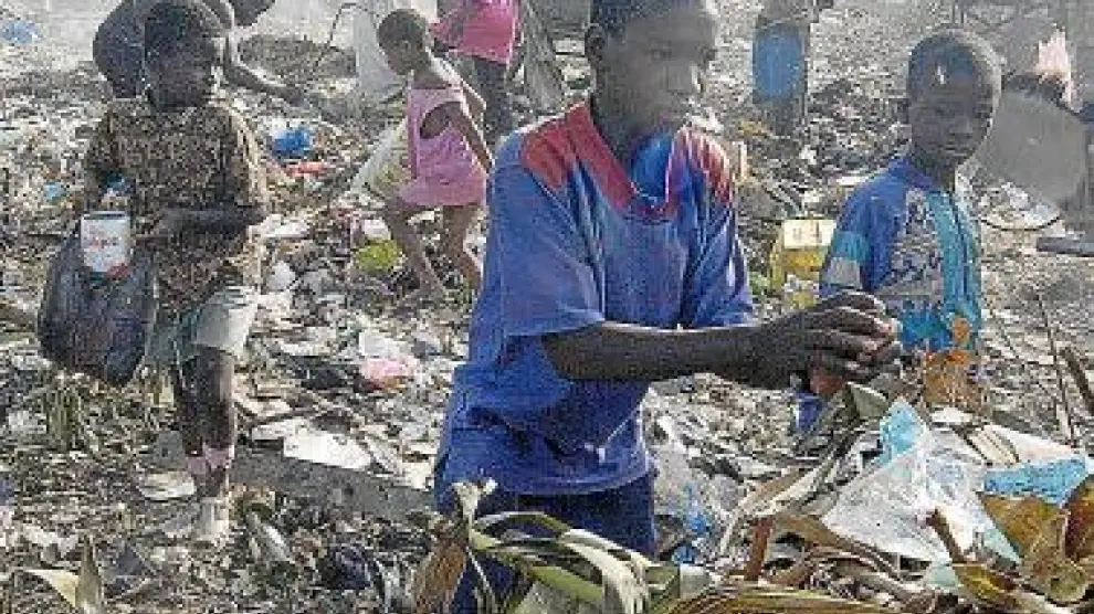 Varios niños de Mali recogen basura en un vertedero.