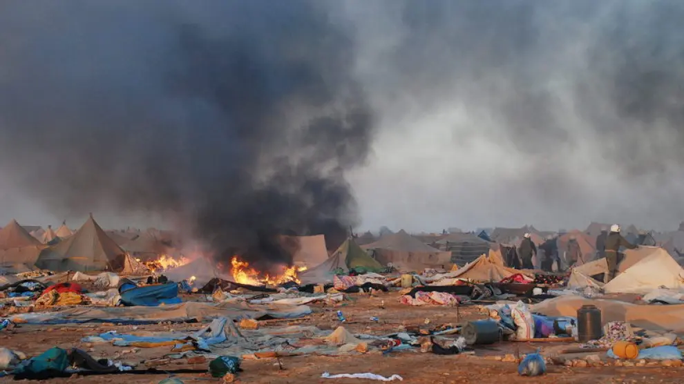 En el campamento desalojado arden en llamas algunas de las jaimas destruídas