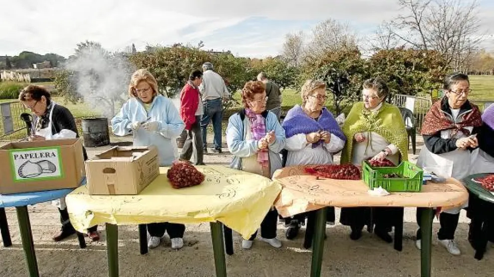 Unas mujeres preparan las castañas que se repartieron ayer gratis en el parque Oliver.