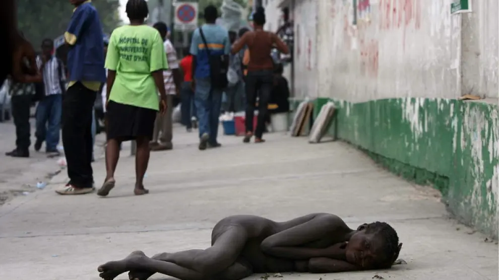 Una mujer enferma de cólera tumbada cerca del Hospital General, en Haití