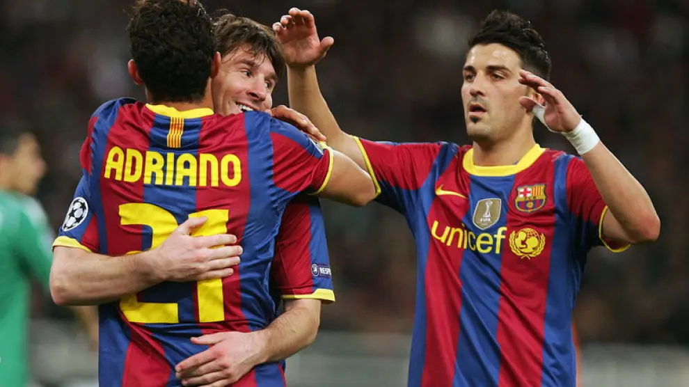Messi se abraza con Adriano para celebrar uno de los goles del Barça