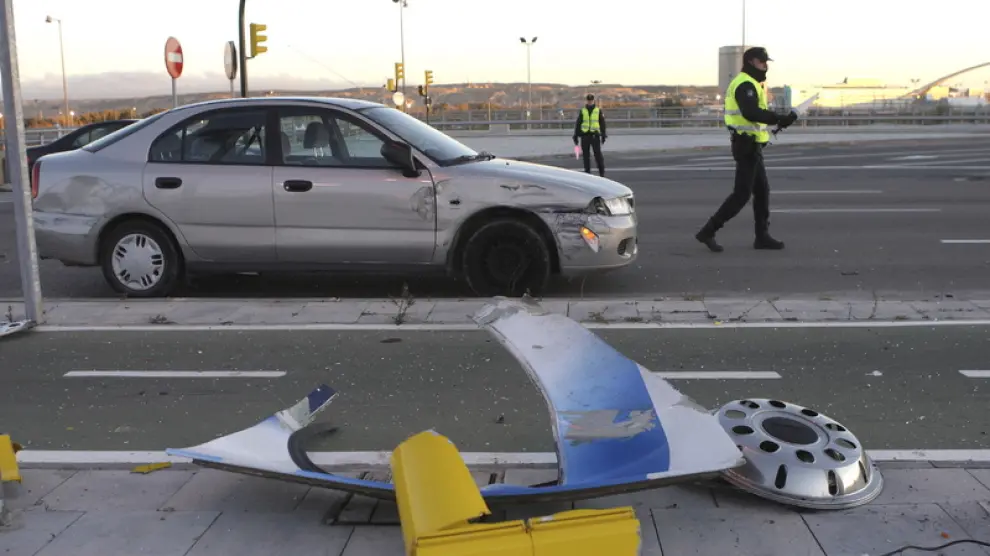 El coche implicado en el accidente, junto a varios objetos de la calzada destrozados