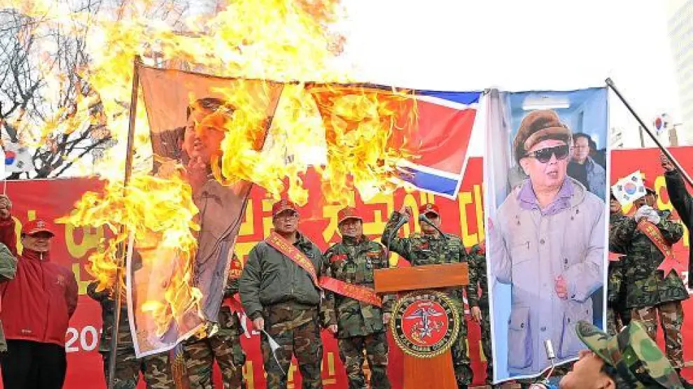 Veteranos militares surcoreanos queman banderas y fotos de los líderes norcoreanos, ayer en Seul.