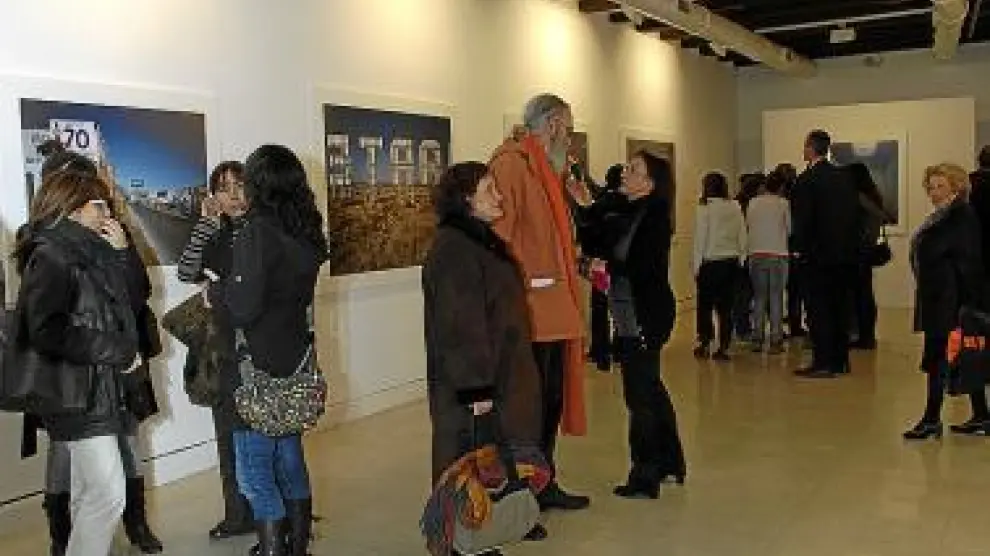 Varias personas contemplan la exposición en la inauguración.