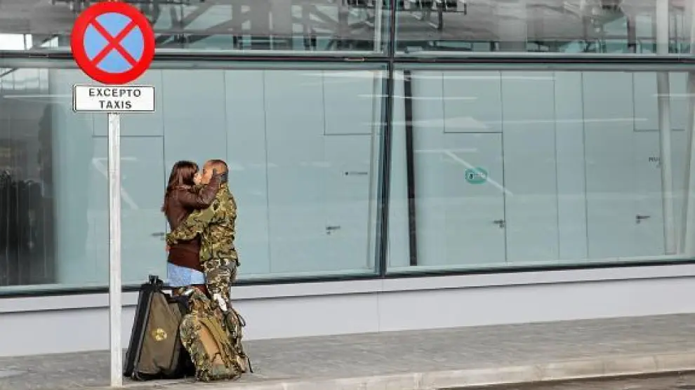 Un militar de la Brigada de Caballería Castillejos II besa a su pareja, ayer, en el aeropuerto de Zaragoza.