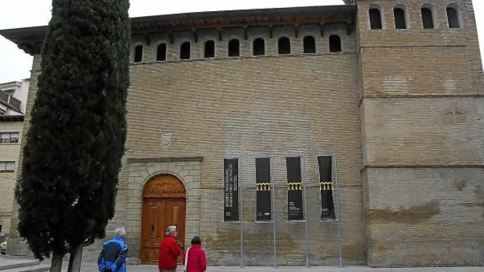 Varias personas pasan junto al museo, que conserva el aspecto exterior de estilo gótico aragonés.