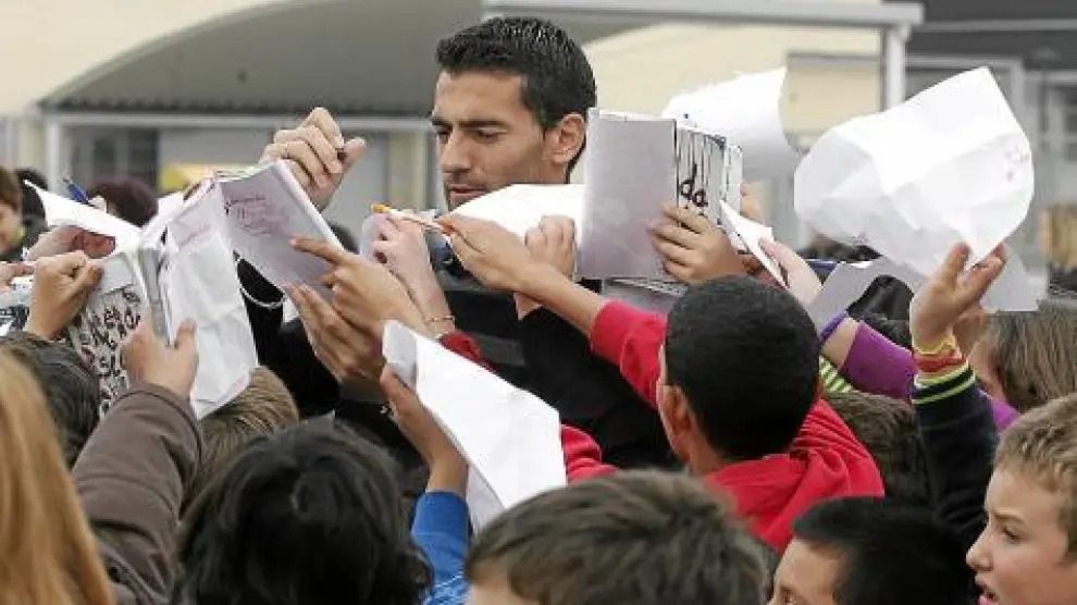 Roberto García firma autógrafos entre una nube de niños.