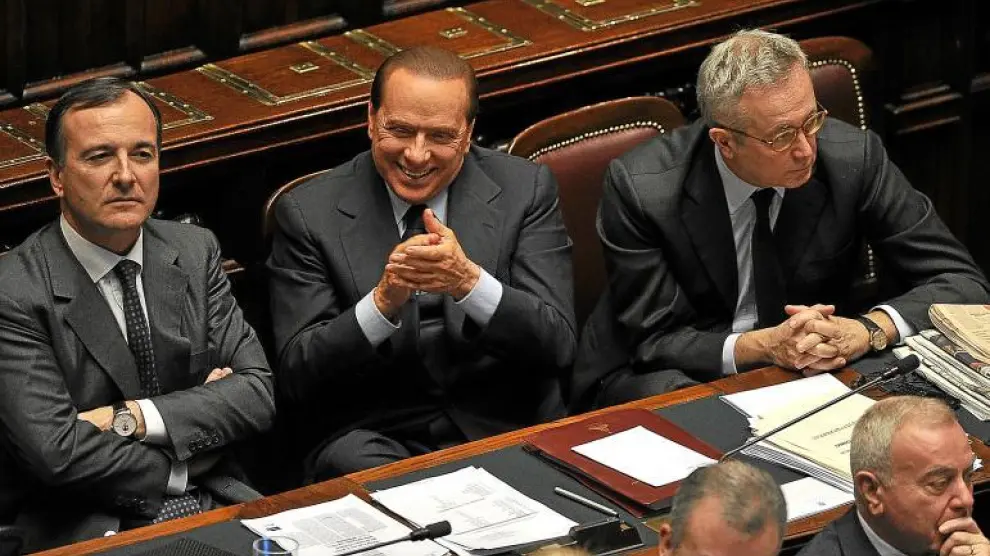 Berlusconi, flanqueado por sus ministros de Exteriores, Frattini, y de Economía, Tremonti, aplaudiendo ayer en el Congreso italiano.
