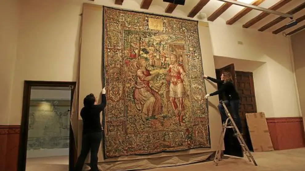 Dos trabajadoras de la Fundación colocan un tapiz en el Museo Episcopal.