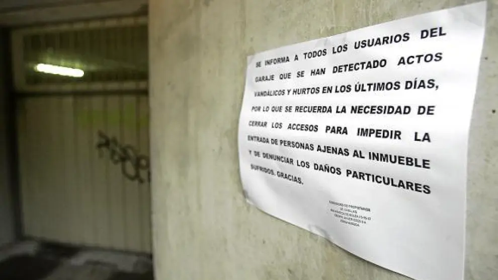 Un cartel alerta a los vecinos de un bloque del Polígono 24 de Huesca de los hurtos en garajes.