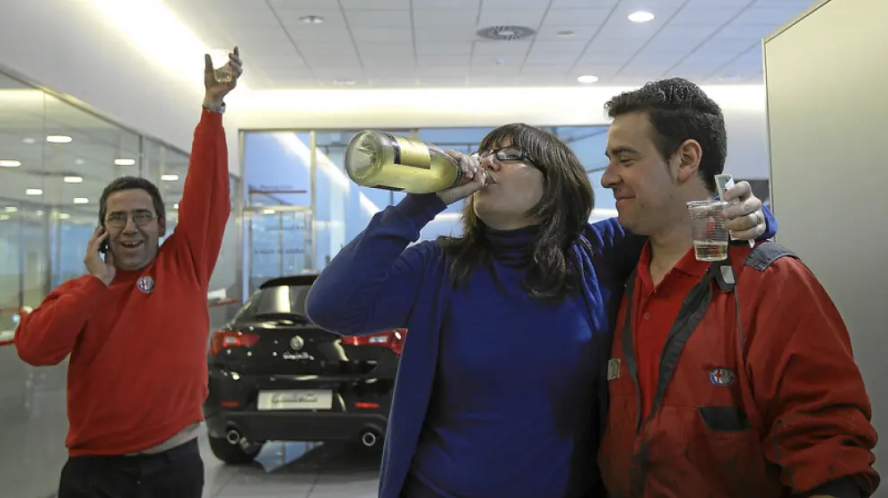 Trabajadores de Alfa Romeo celebran que les ha tocado el 2º premio de la lotería. Algunos empleados tienen más de tres décimos.