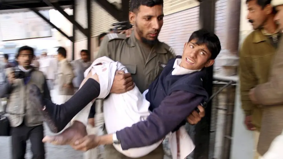 Un soldado traslada a un joven herido en el atentado de Khar