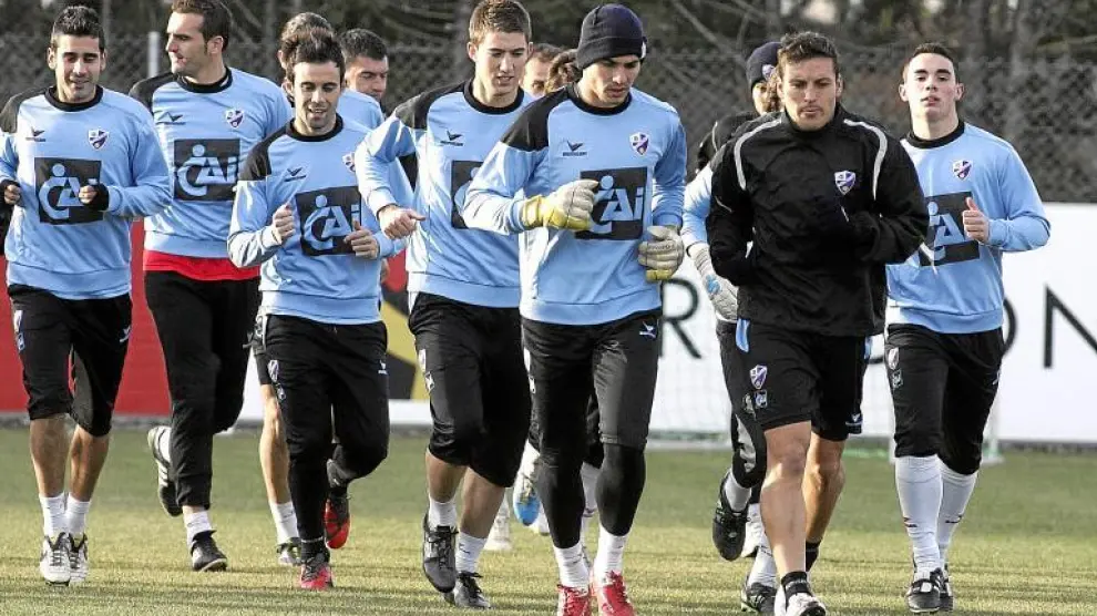 Algunos de los futbolistas de la Sociedad Deportiva Huesca, durante el entrenamiento de ayer en el IES Pirámide.