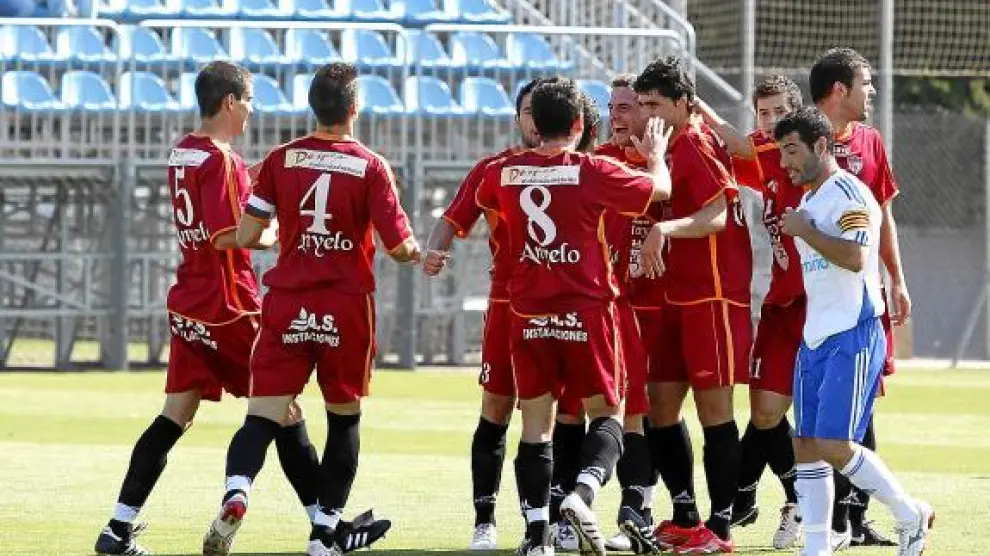 Los jugadores del Calatayud celebran un gol mientras Adrián Barba se lamenta.