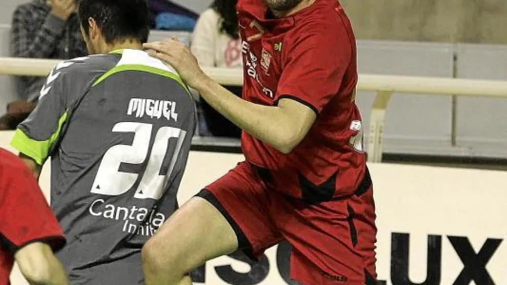 Emilio Esteban salva la oposición del extremo Miguel Martínez y se dispone a pasar el balón.