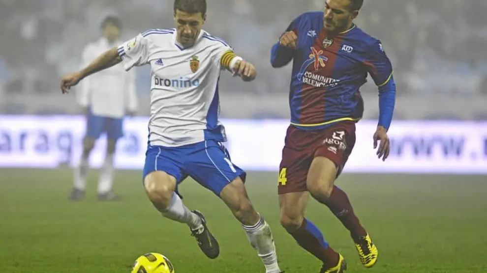 Gabi protege una pelota ante la acometida del centrocampista rival, Xavi Torres.