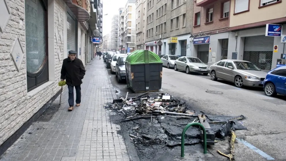 Restos de un contenedor quemado en la calle Ávila.