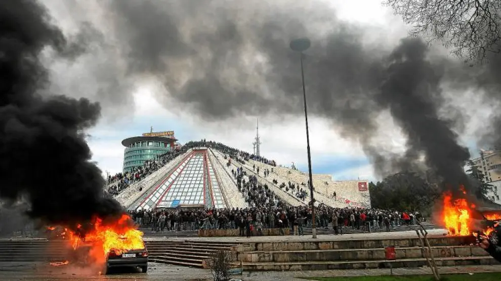 Coches ardiendo y cientos de personas frente a la sede del Gobierno de Albania, en Tirana.