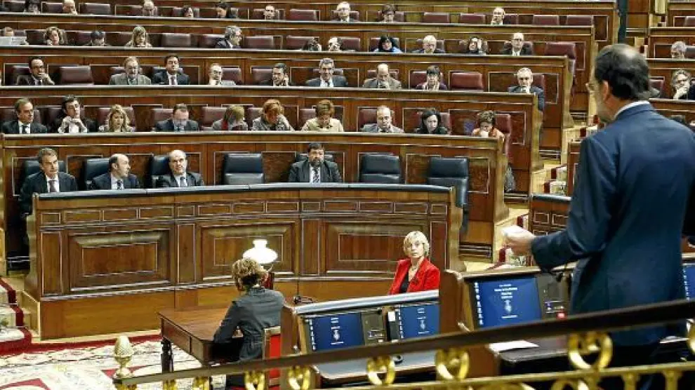 Rajoy (derecha, de espaldas) se dirige al presidente del Gobierno (izquierda), ayer en el Congreso.