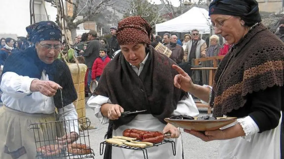 Un grupo de mujeres de la Festa del Tosino de Albelda muestran algunos de los productos del cerdo.
