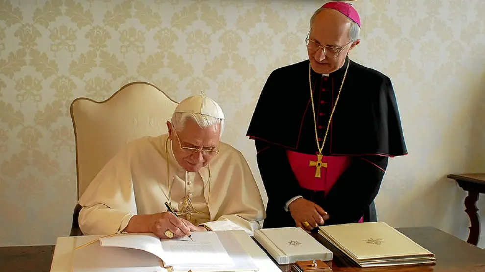 Benedicto XVI escribe en presencia del obispo Fernando Filioni