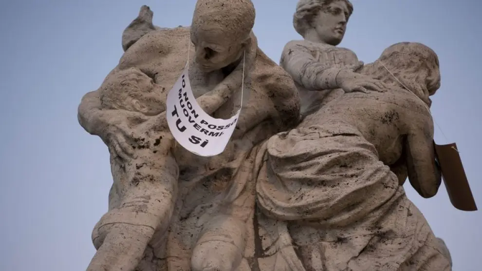 Fotografía cedida por Nessun Dorma que muestra una estatua con un cartel en el que se lee «Yo no puedo moverme. Tu si»