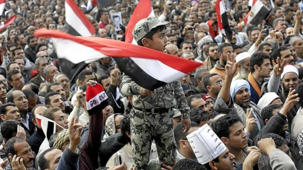 Un niño vestido de soldado y subido a hombros ondea una bandera de Egipto durante la masiva manifestación de ayer en El Cairo.