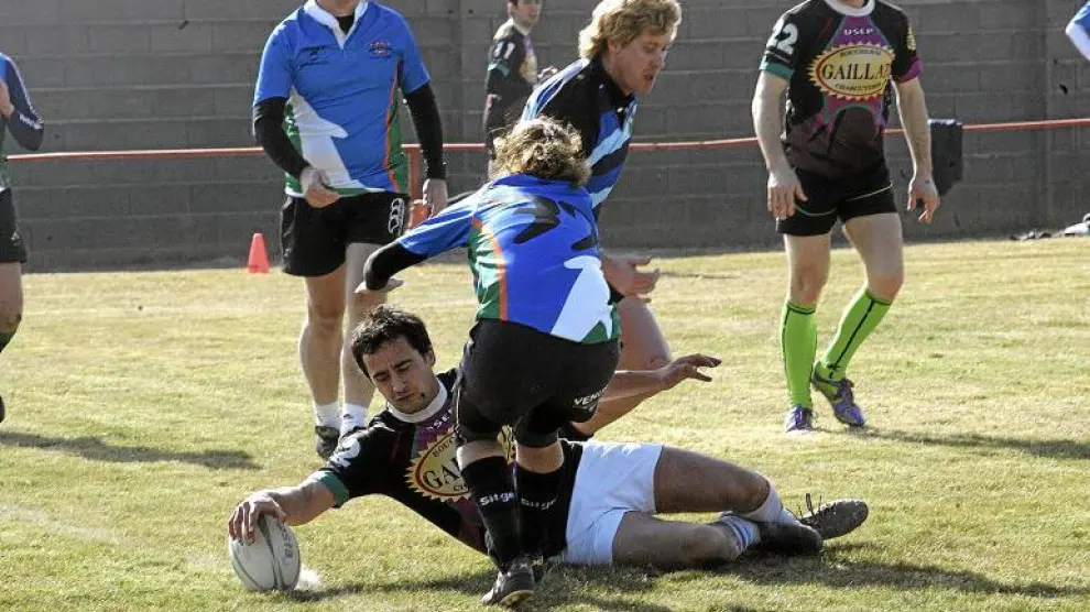 El equipo Touch Pyrénéés Rugby de Tarbes, Francia, consigue anotar un ensayo pese a la oposición de una jugadora rival.