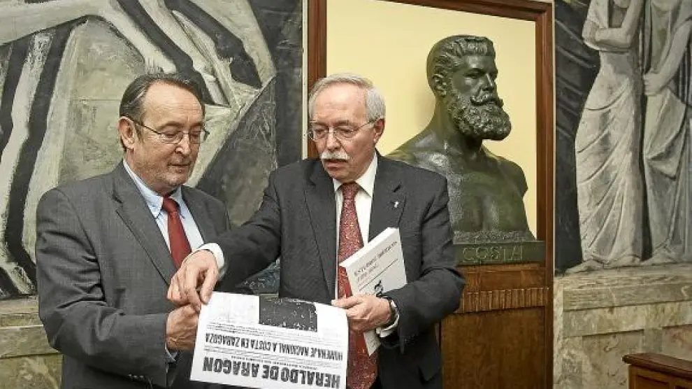 Carlos Forcadell (izquierda) y Guillermo Fatás leen sobre Costa en una edición antigua de HERALDO.