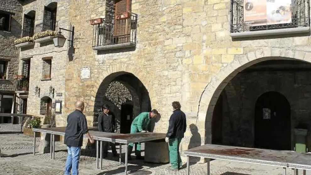 Los operarios preparaban ayer las mesas en la plaza y cocinas improvisadas bajo los porches.