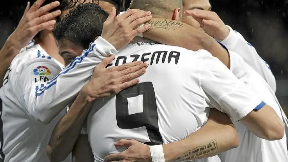 Los jugadores del Real Madrid se abrazan a Benzema, autor del primer gol del partido.