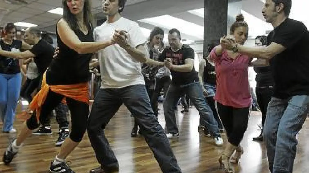 Varios participantes bailan salsa en uno de los talleres.