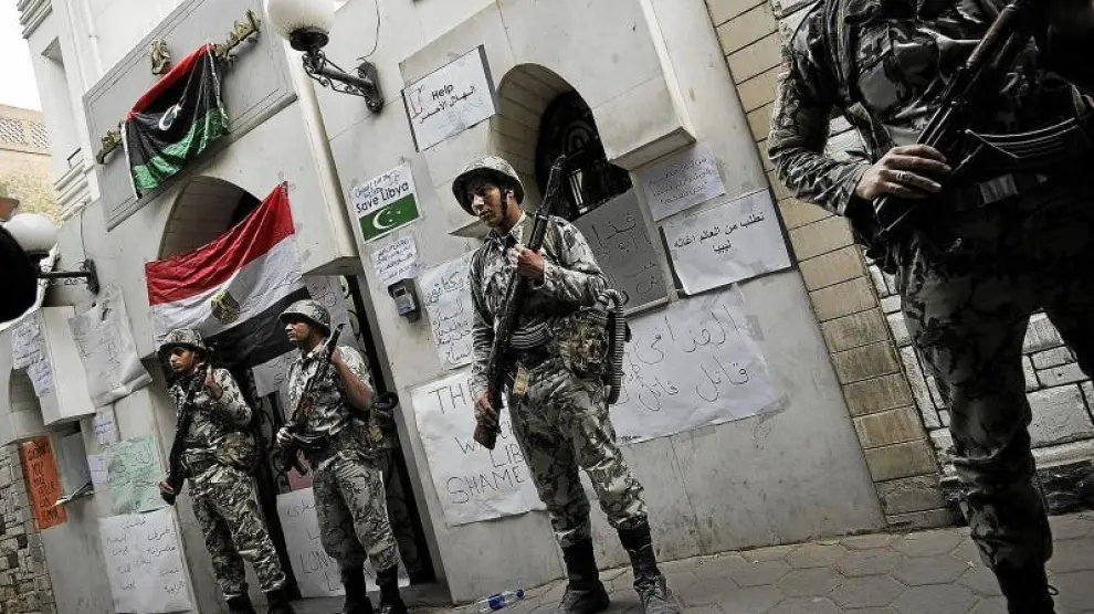 Soldados egipcios custodian la embajada de Libia en El Cairo, repleta de carteles contra el régimen.