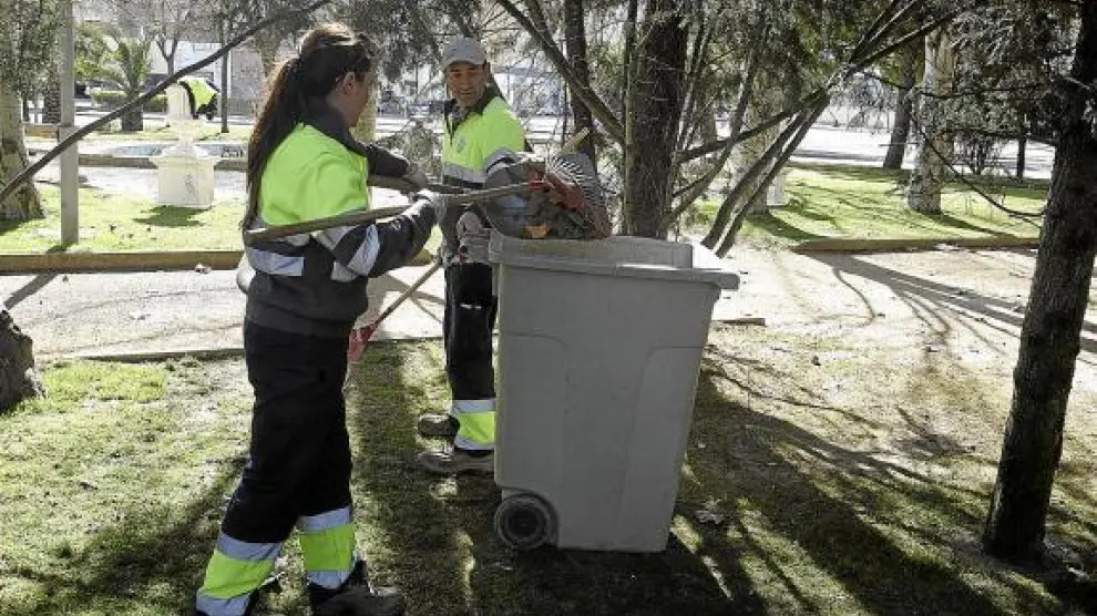 Dos empleados de la brigada limpian una de las decenas de zonas verdes que hay en la ciudad.