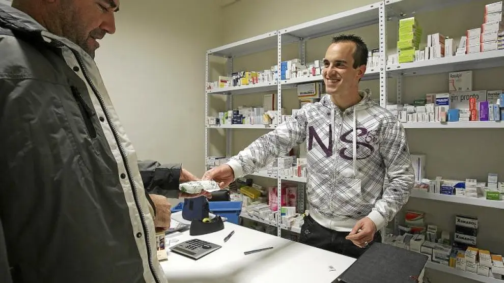 El farmacéutico de Loporzano atiende a un cliente en el dispensario de Tierz.
