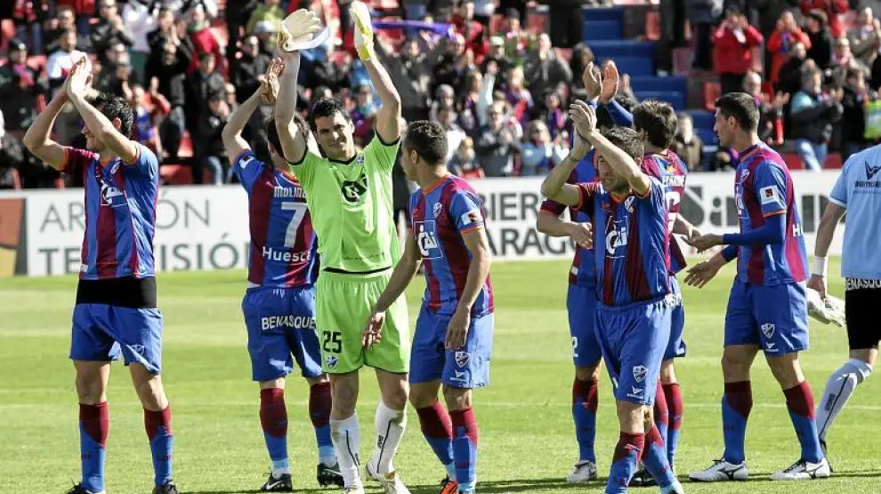 Los jugadores del Huesca saludan a la grada desde el centro del campo con la victoria en el bolsillo. Antes, El Alcoraz hizo la ola.