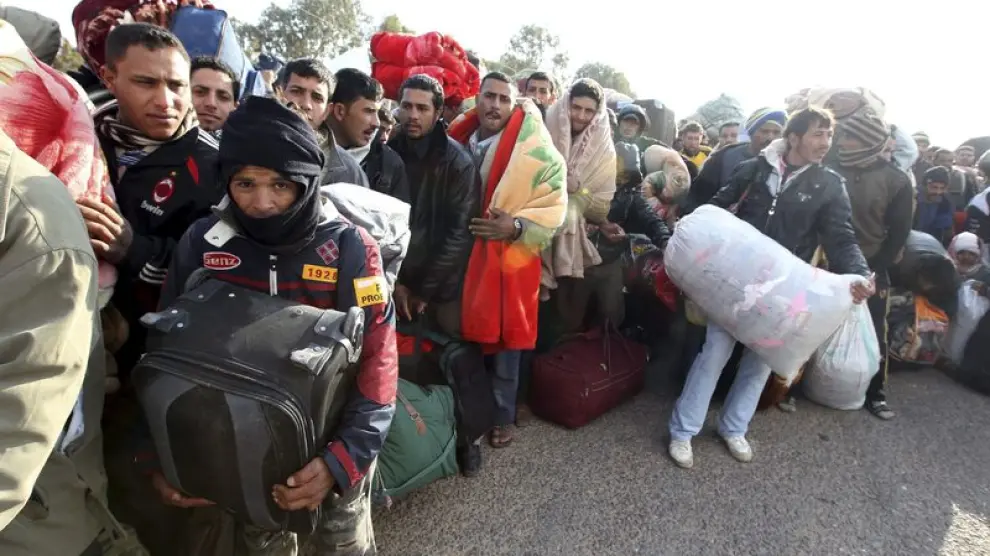 Ciudadanos egipcios residentes en Libia esperan junto a sus pertenencias en el paso tunecino de Ras el Jedir