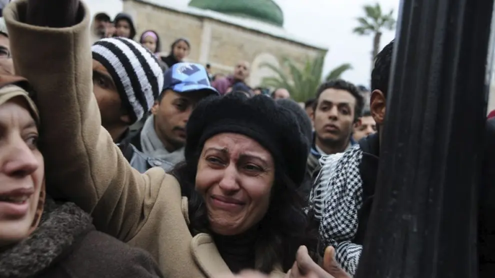 Una manifestante tunecina que llora, mientras cargan el ataúd del manifestante muerto