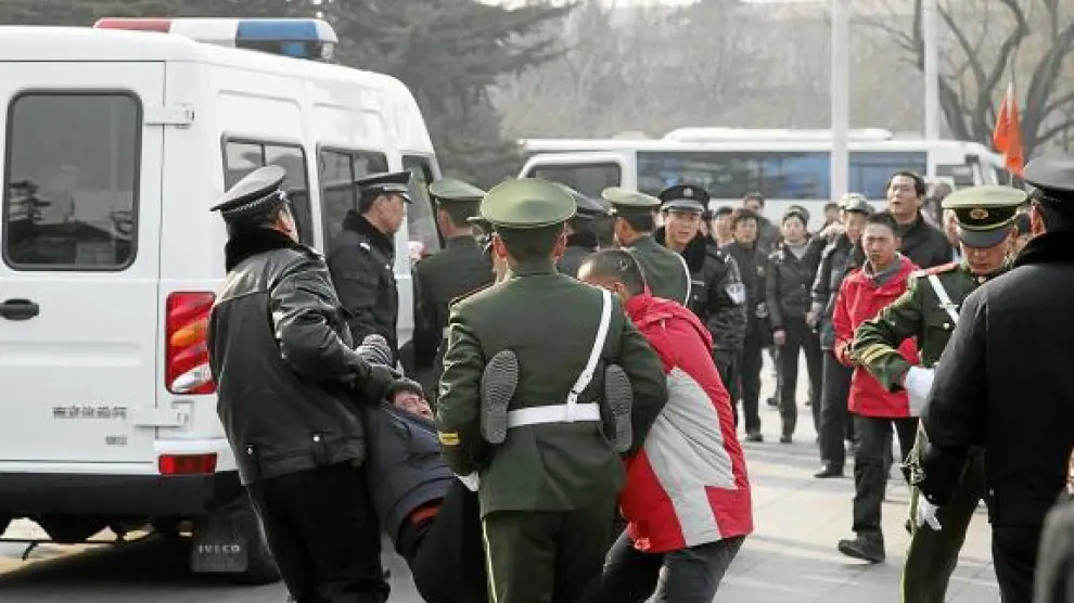 Agentes arrestan a un manifestante coincidiendo con la sesión de la ANP el día 5 de marzo en Pekín.