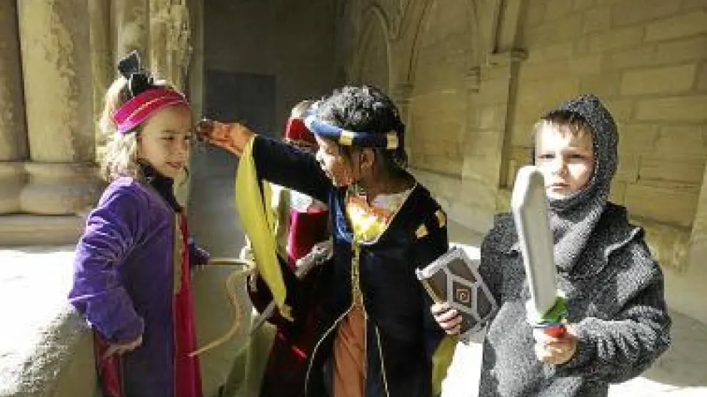 Unos niños, vestidos de personajes medievales, durante uno de los talleres didácticos.