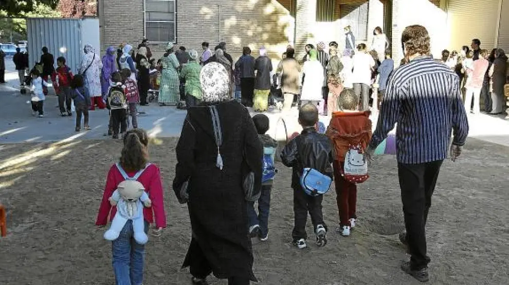 Una mayoría de padres inmigrantes, en esta foto de archivo, esperan a las puertas del Pío XII la salida de los niños de clase.