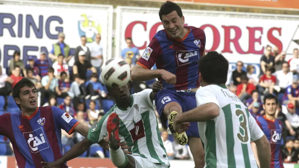 Joaquín Sorribas trata de rematar ante la oposición de dos jugadores del Córdoba y la mirada de su compañero Toni.