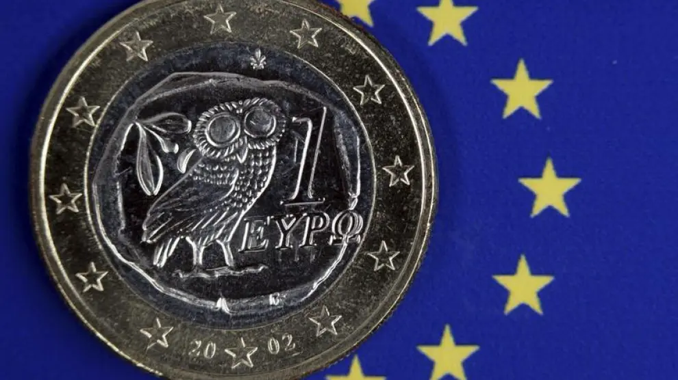 Una moneda de euro griego permanece sobre el emblema de la Unión Europea