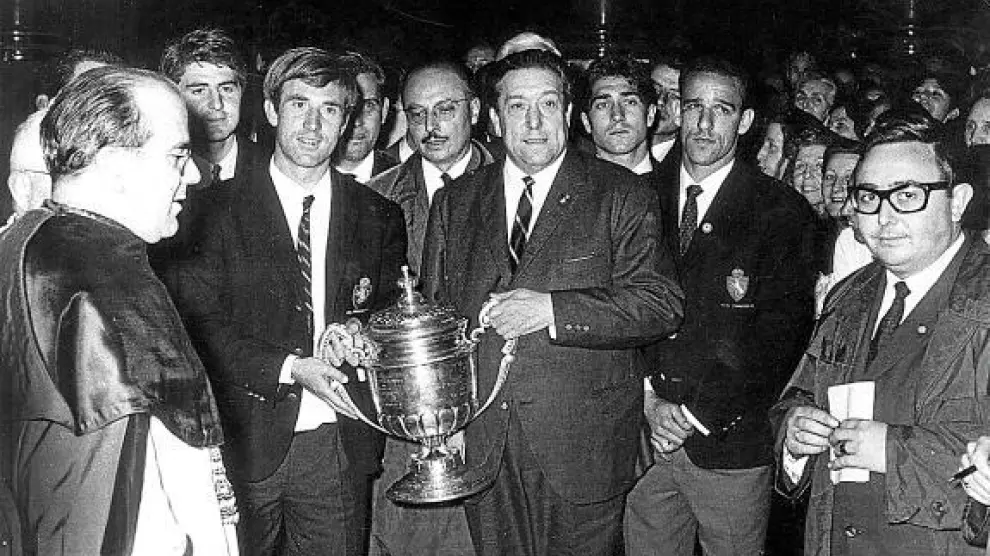Lapetra sujeta el trofeo de Copa conseguido por el Real Zaragoza en 1966. Lo hace a la vez con Waldo Marco, presidente en aquella época. A la derecha figura el brasileño Canario.