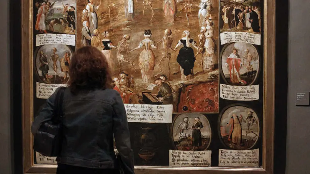 Una mujer contempla el cuadro 'La danza de la muerte', que forma parte de la exposición